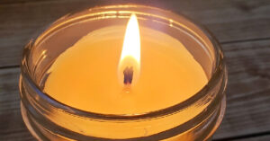 DIY beeswax candle lit on a table