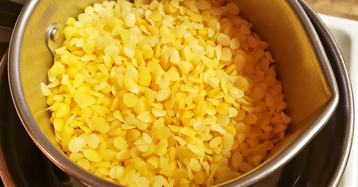 Close up of beeswax pellets in a candle pouring pitcher