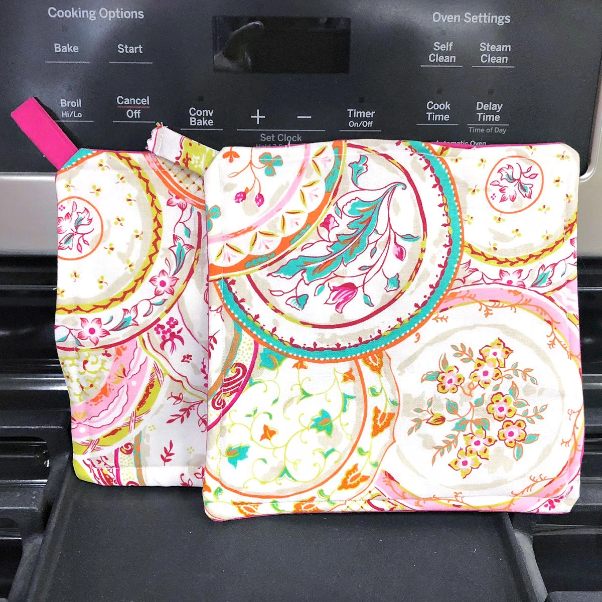 Two homemade paisley printed pot holders on an oven
