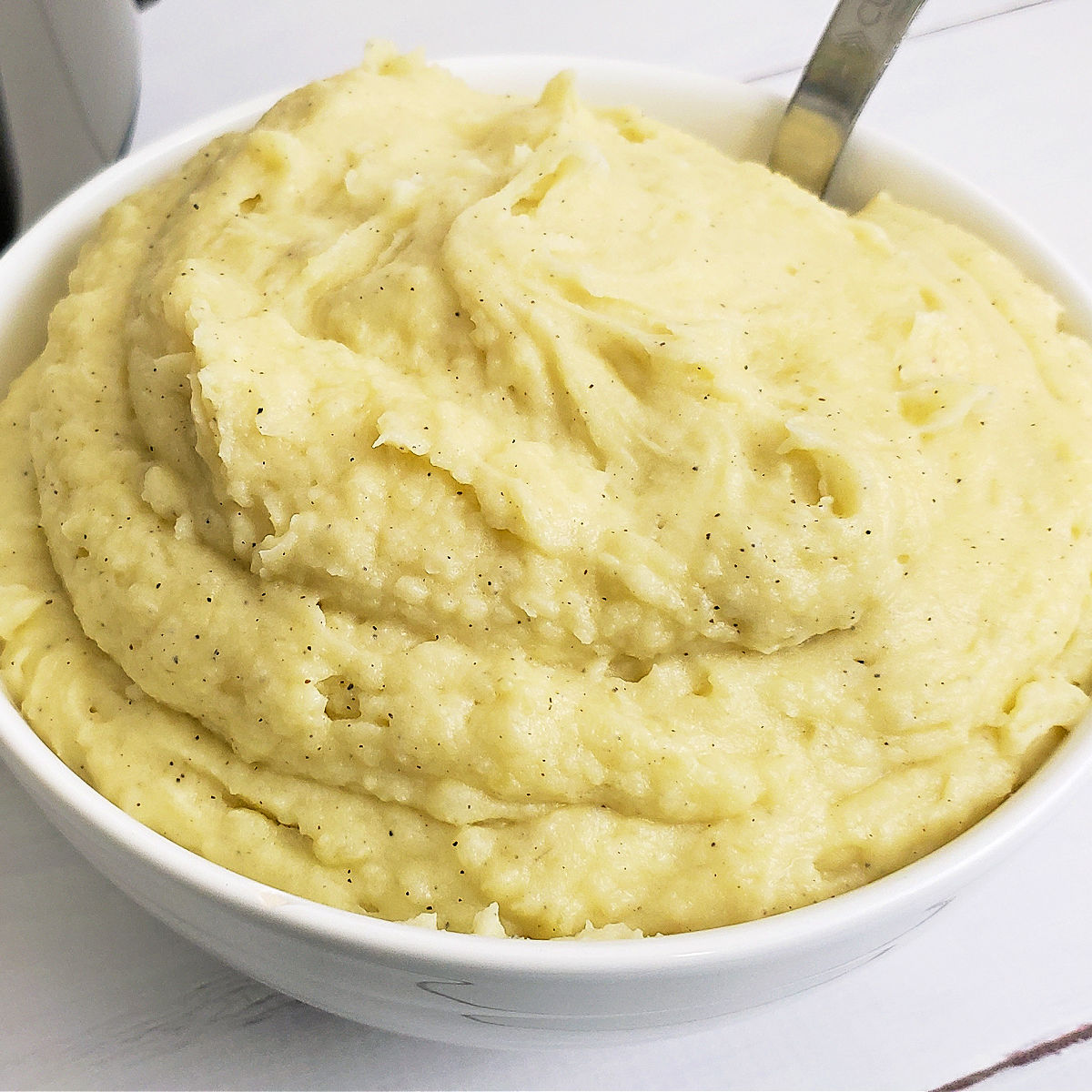 Fluffy Instant Pot Mashed Potatoes in serving bowl with spoon.