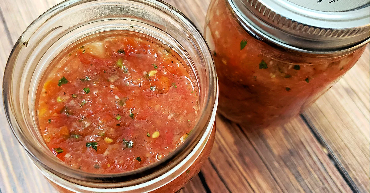 Fresh garden salsa in two pint sized mason jars.