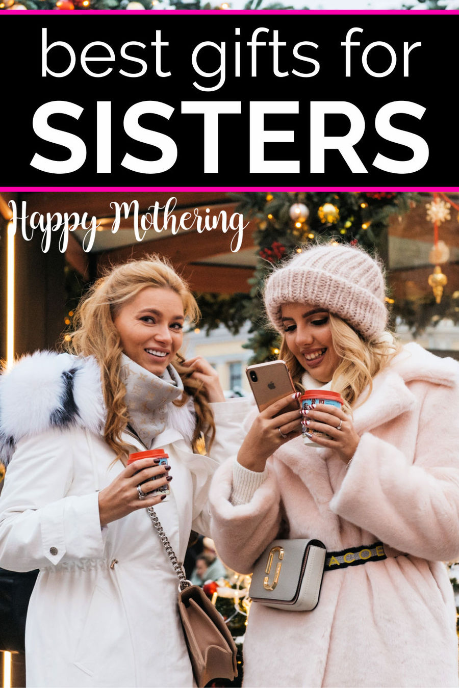 Two sisters at a mall during Christmas time all bundled up and talking while looking at a phone