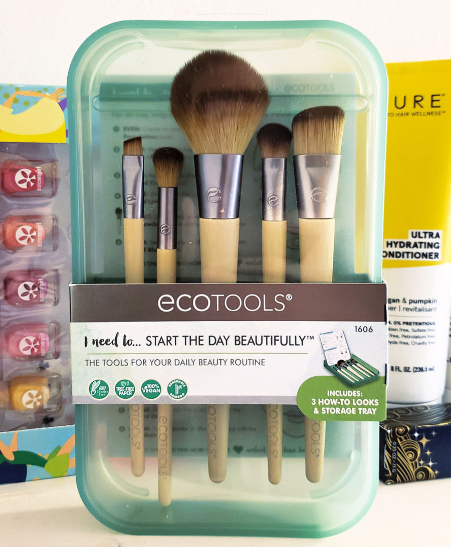 Ecotools Makeup Brushes in clear green case in front of personal care product bottles.