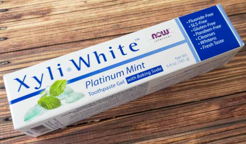 Now Solutions Xyli-White Platinum Mint Toothpaste on a wood table.