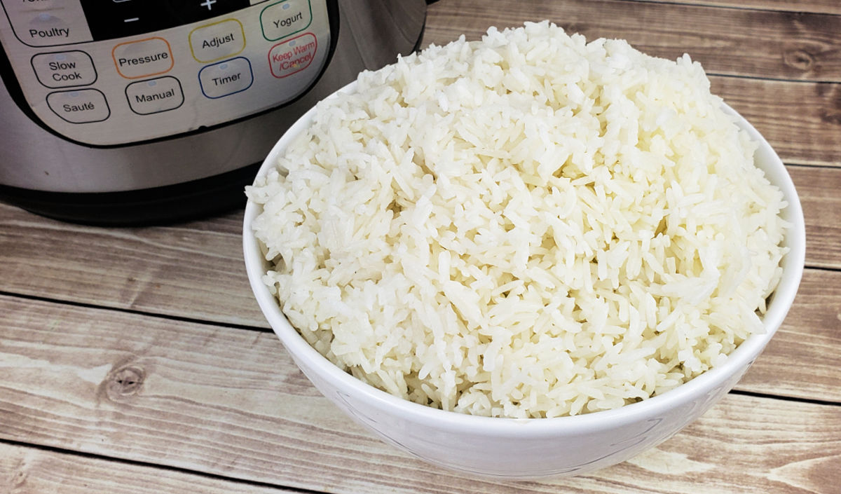 White ceramic bowl filled with Jasmine Rice next to an Instant Pot, ready to be served for dinner.