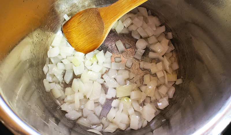 Chopped onion being sauteed in an Instant Pot.