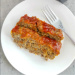 2 slices of gluten free meatloaf on white plate with fork.
