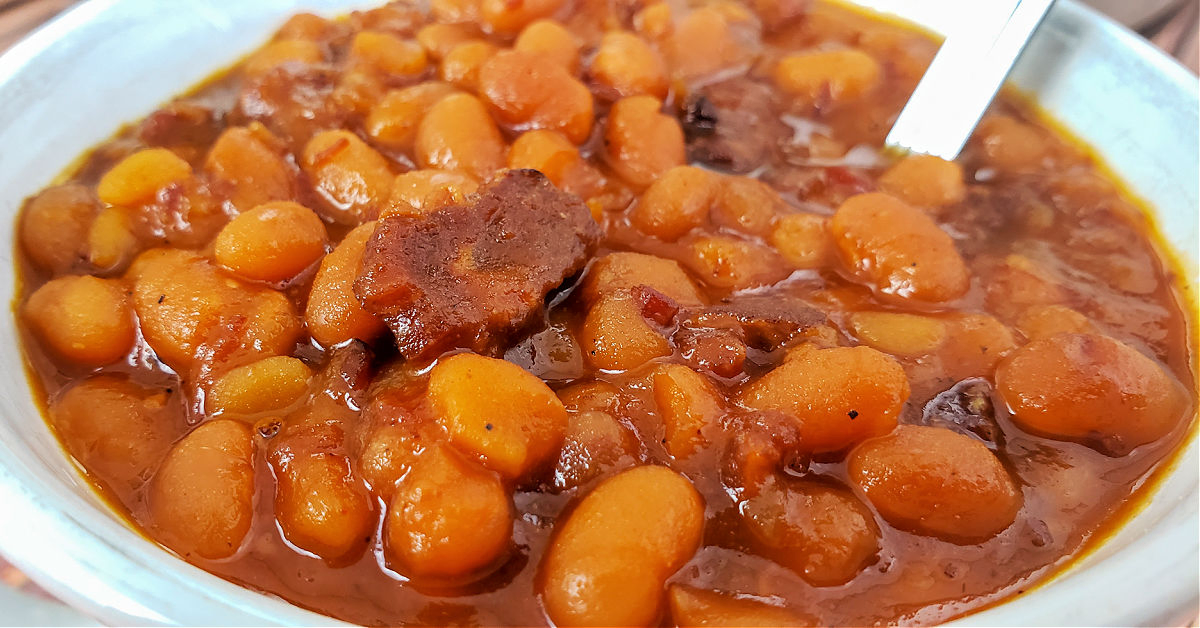 Close up of baked beans that were made in an Instant Pot in a bowl with a spoon.