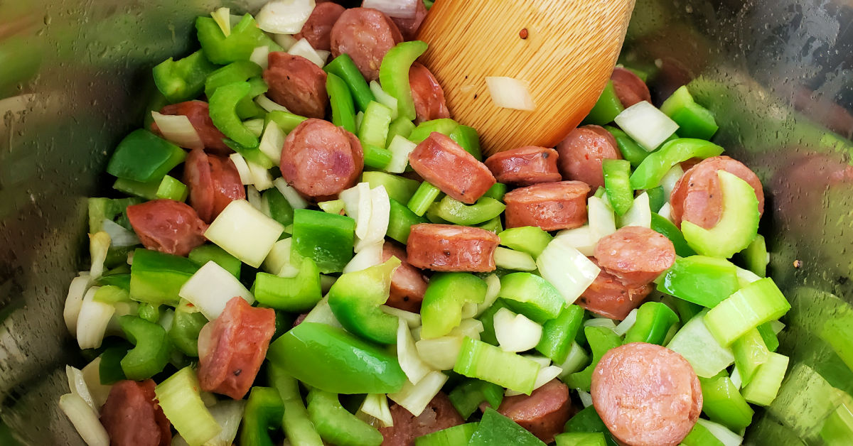 Green bell pepper, celery and onion being sautéed with Andouille sausage in Instant Pot inner pan.