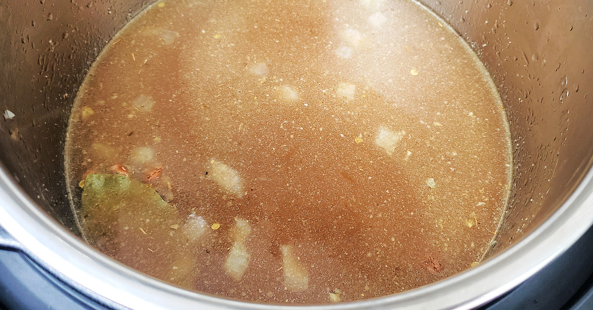 Chicken stock and beans added to Instant Pot with sauteed onion, garlic and jalapeno.