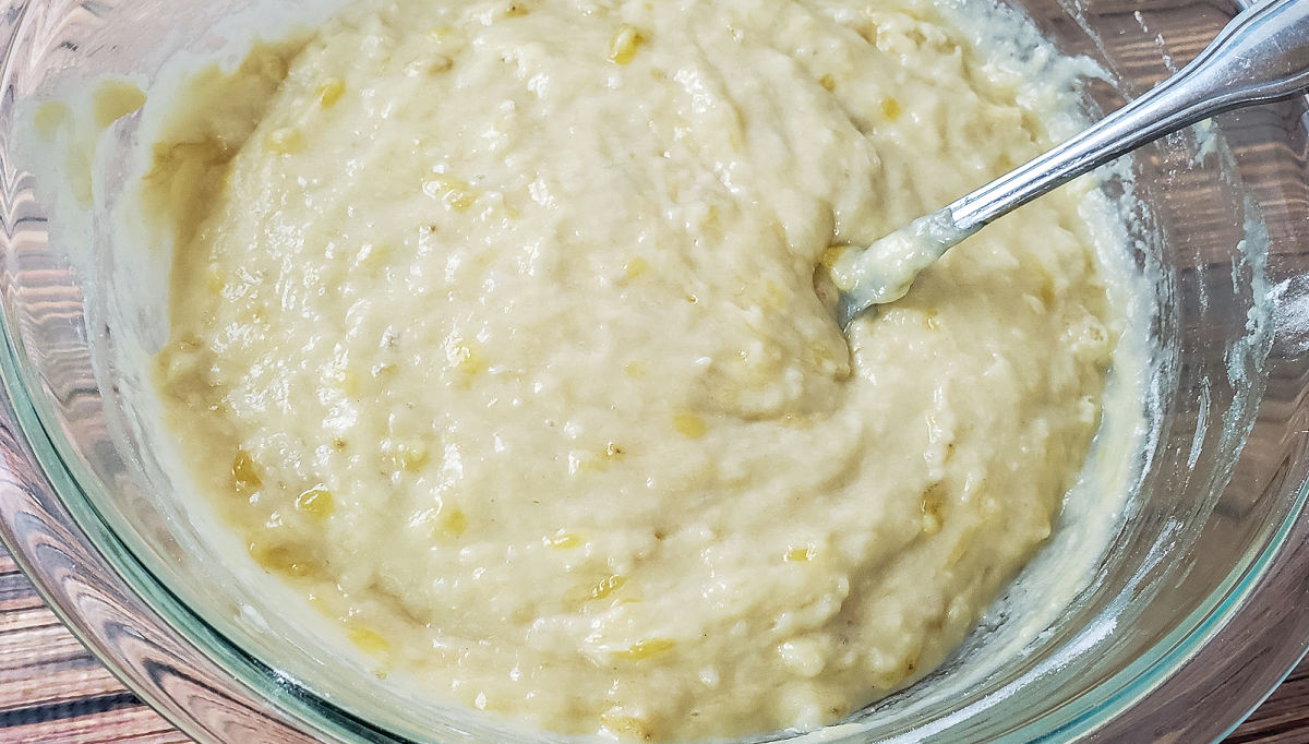Gluten free banana muffins batter being whisked by hand in mixing bowl.