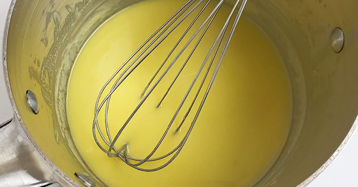 Butter and gluten free flour being whisked together in saucepan.