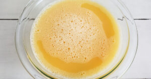 Egg and turkey stock mixture in glass mixing bowl.