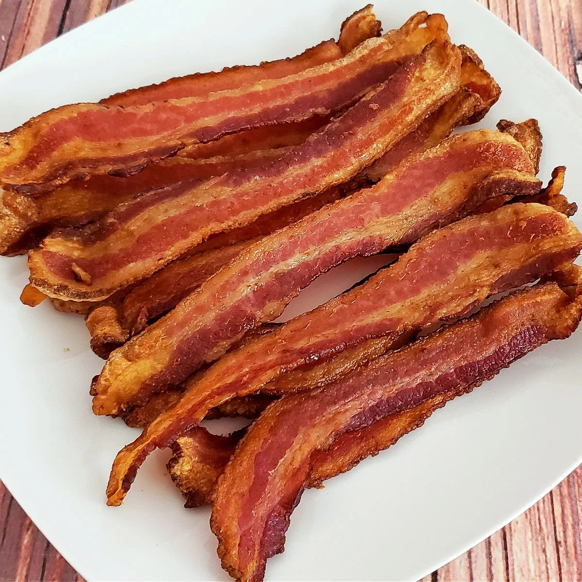 Air fryer bacon on square white plate.