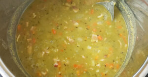 Split pea soup being served with spoon from Instant Pot.