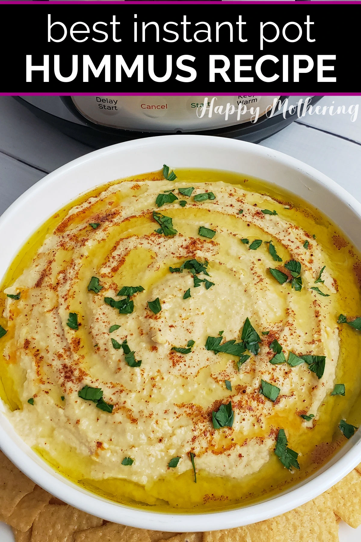Instant Pot Hummus garnished with olive oil, parsley and paprika in white serving bowl with gluten free crackers.
