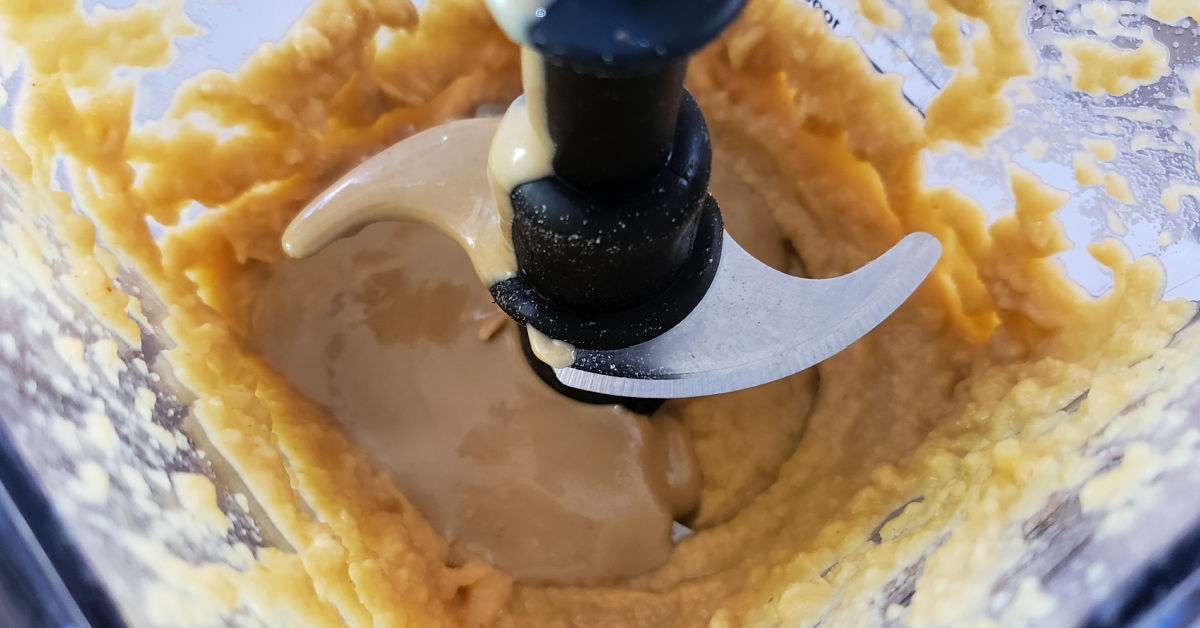 Tahini added to blender with other hummus ingredients.