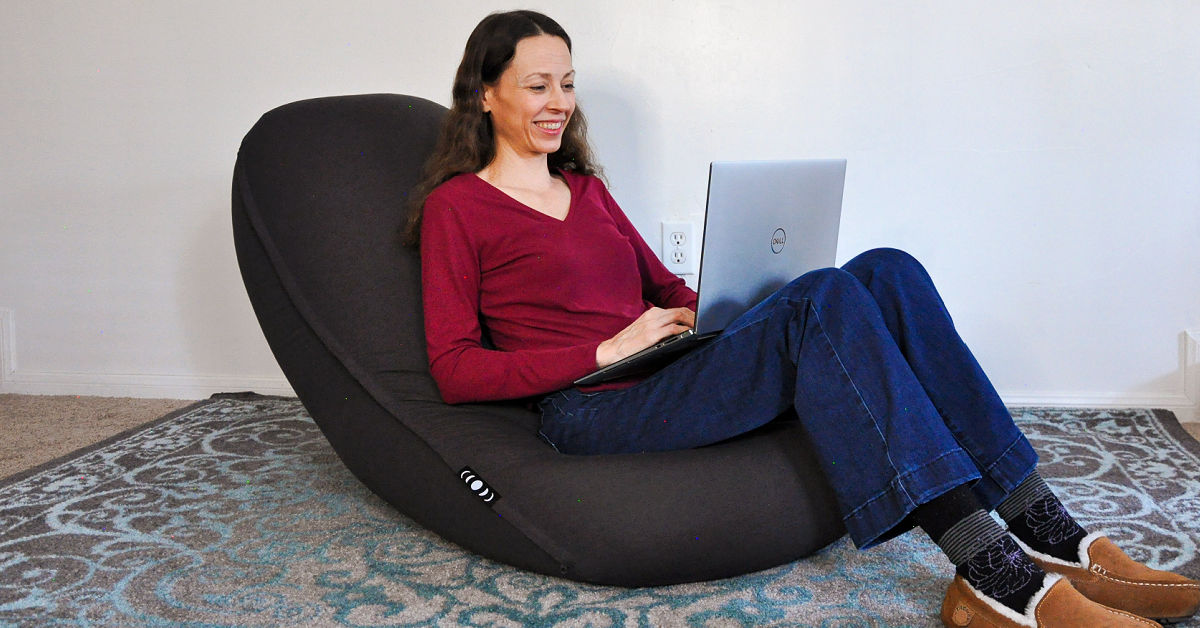 Chrystal with laptop sitting in Moon Pod beanbag chair.