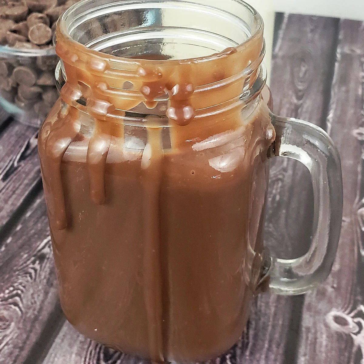 Chocolate sauce in pint jar, dripping down the sides.