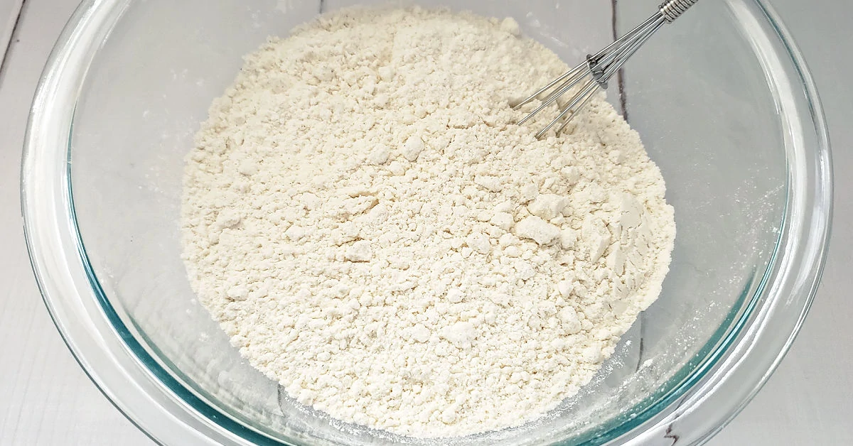 Gluten free flour, sea salt and baking soda being whisked together in mixing bowl.