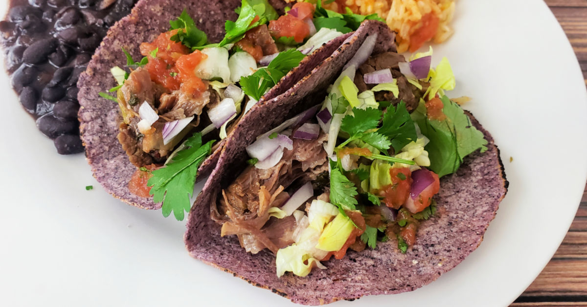 Blue corn tortilla tacos served with black beans.