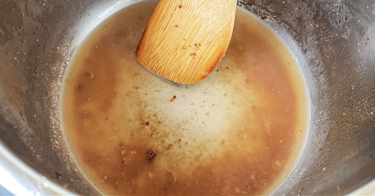 Instant Pot being deglazed with chicken stock.
