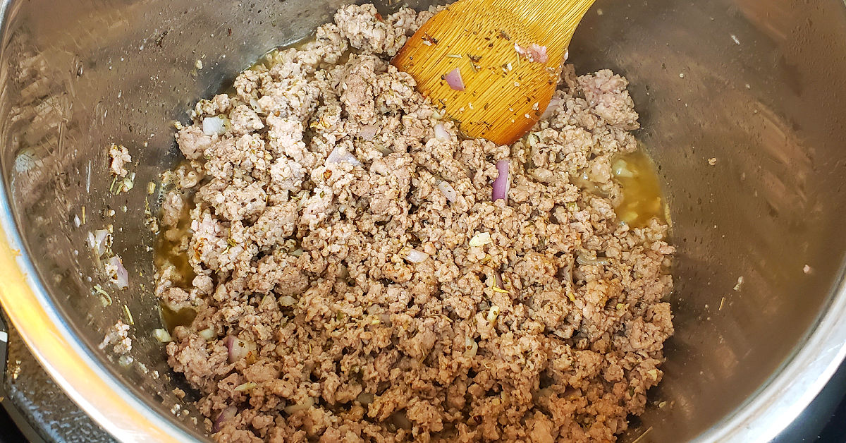 Garlic and onion added to browned ground meat.