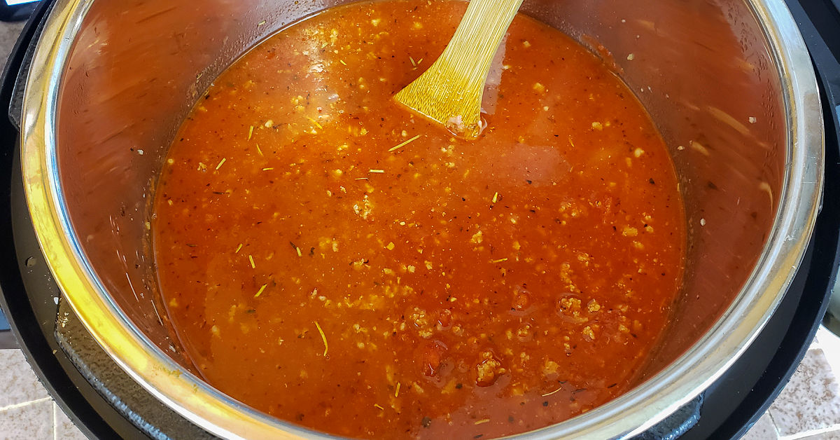 Meat sauce being stirred in Instant Pot.