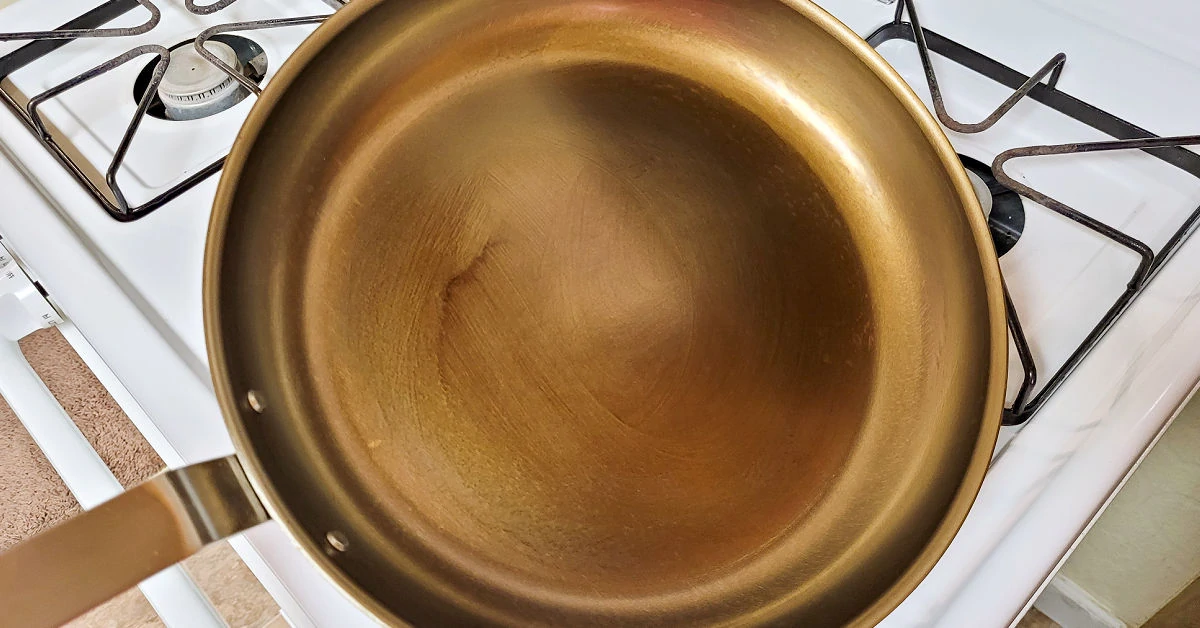 A more fully seasoned carbon steel pan on the stovetop.
