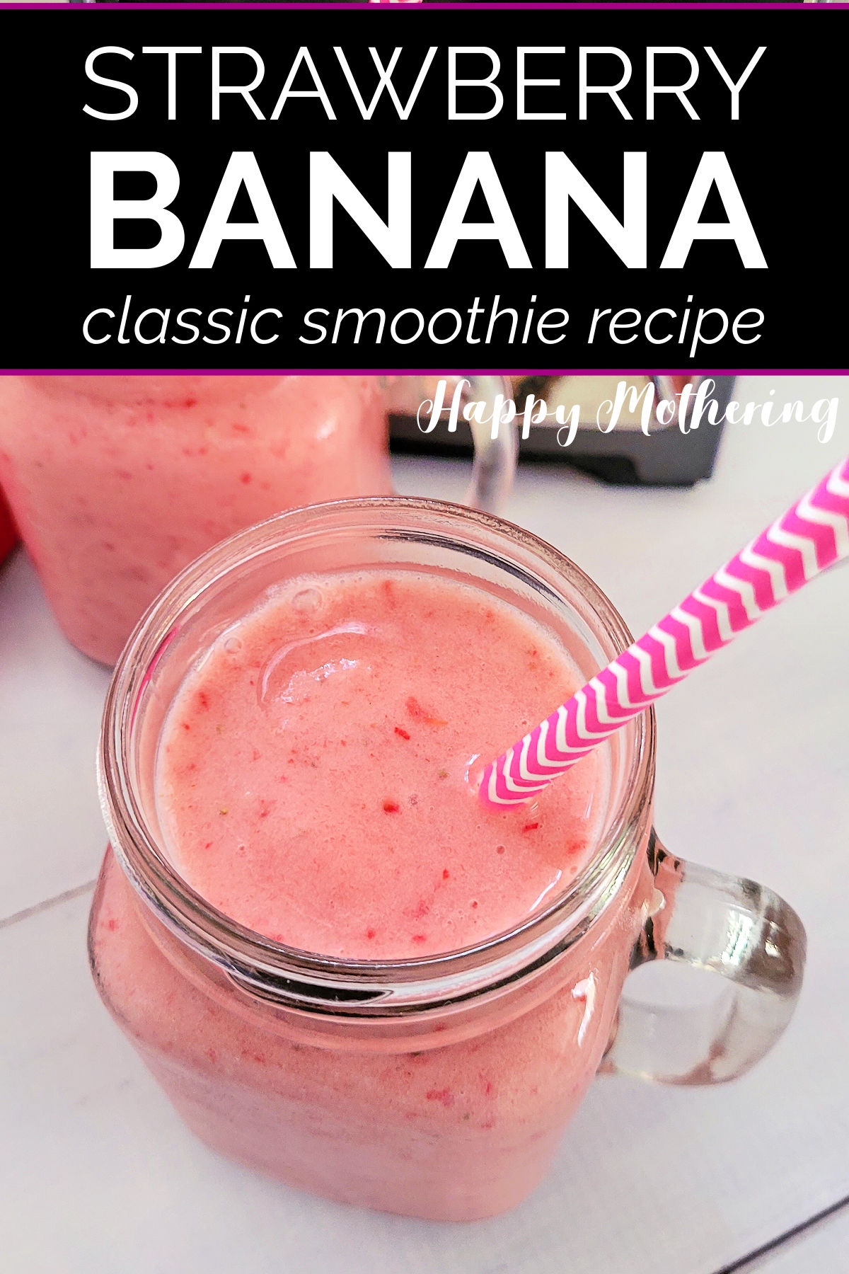 Overhead view of Strawberry Banana Smoothie in pint sized mason jar glass with pink and white straw on white wood table.