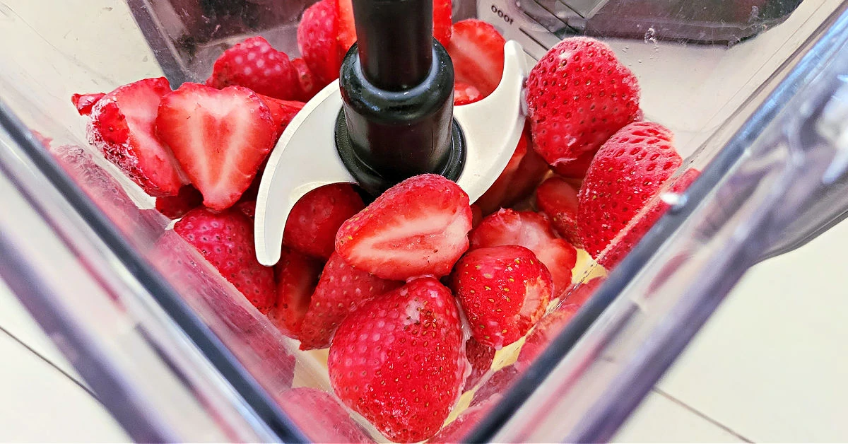 Frozen strawberries, frozen bananas and almond milk in a blender.