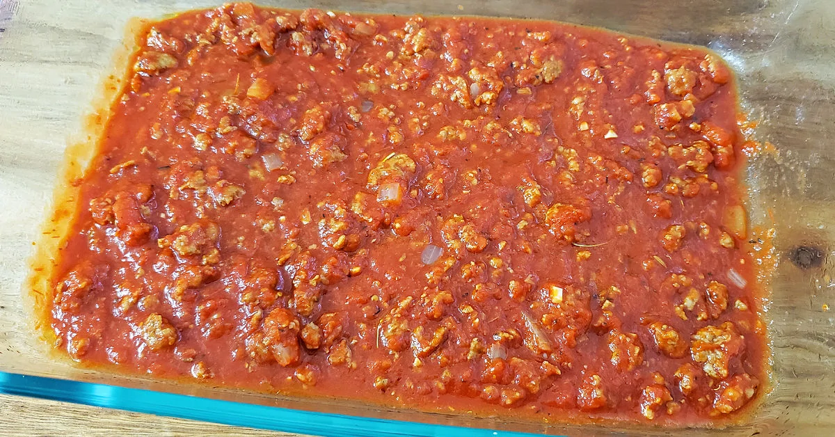 Meat sauce in bottle of lasagna pan.
