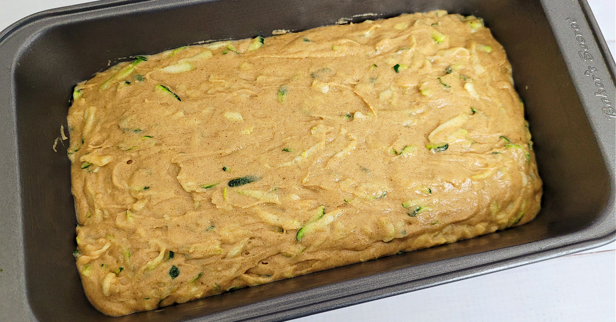 Gluten free zucchini bread batter in a loaf pan ready to be baked.