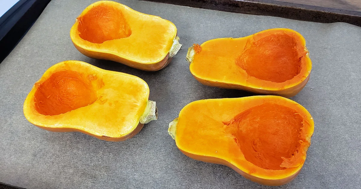 Found honeynut squash halves on a parchment paper lined baking sheet.