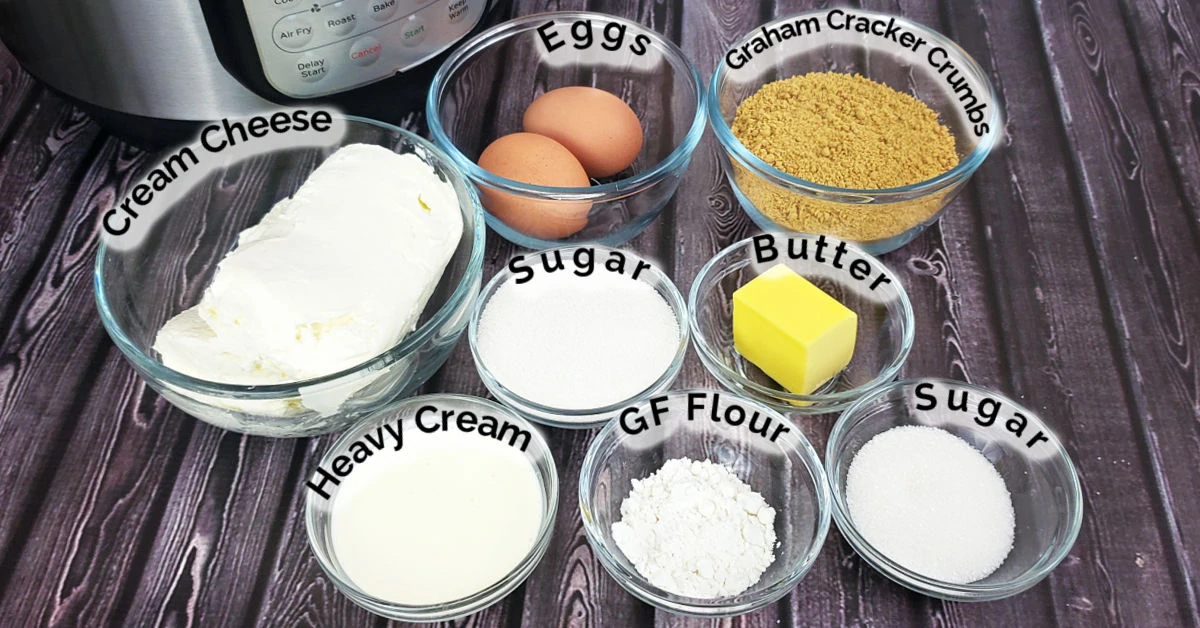 Ingredients for gluten free cheesecake, including cream cheese, eggs, sugar, flour, graham cracker crumbs, butter and heavy cream.