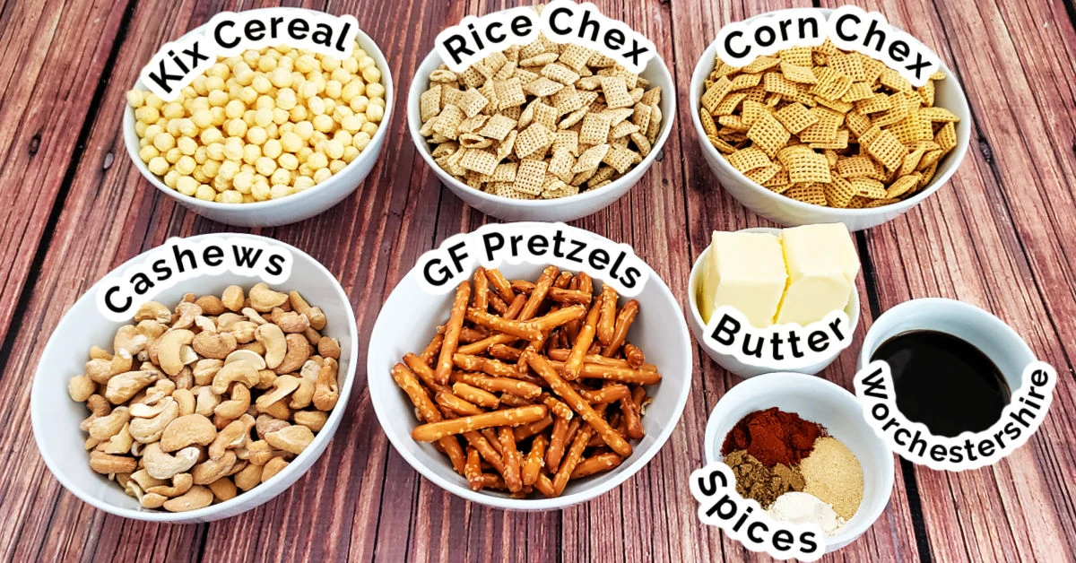 Chex Mix ingredients in white bowls on a wood table.