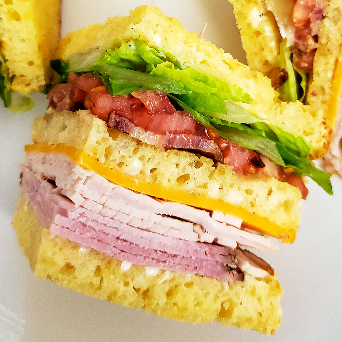 Close up of one quarter of a gluten free club sandwich, showing all of the layers.