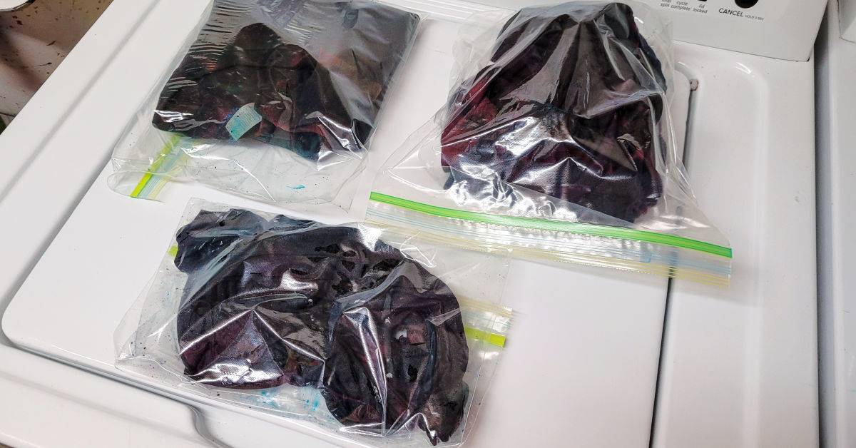 Reverse tie dyed shirts soaking in plastic bags.