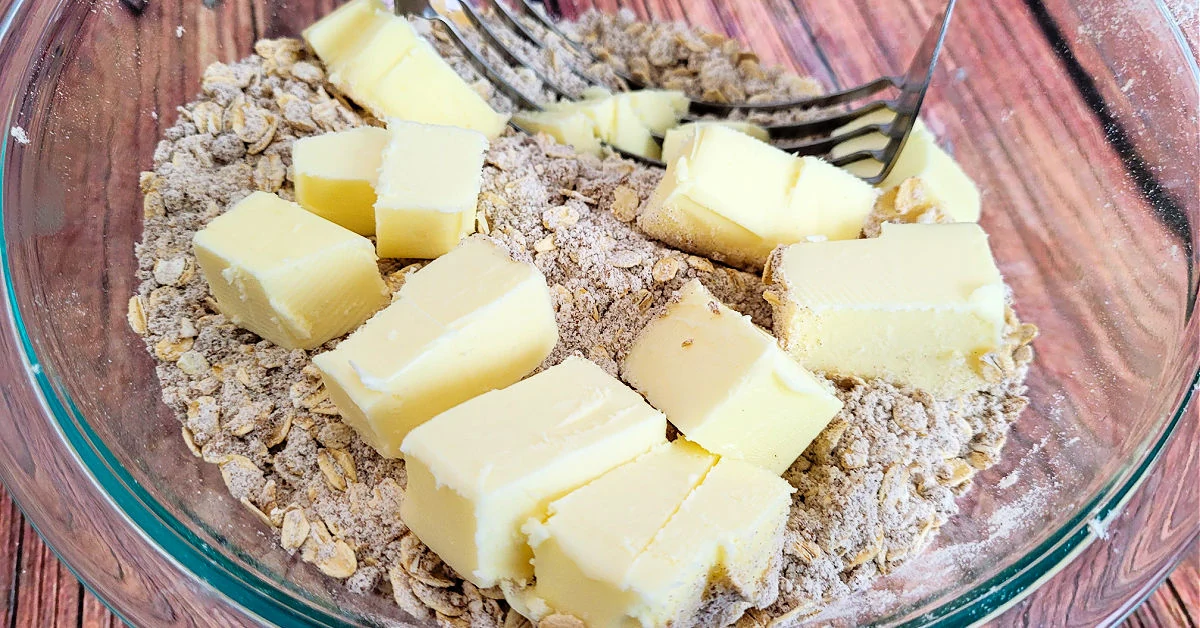 Cold, cubed butter added to dry crisp ingredients.