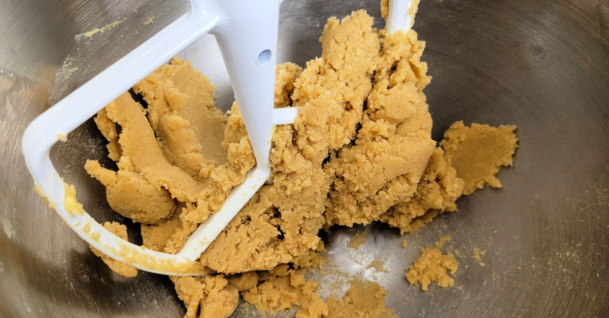 Butter, brown sugar and white sugar being creamed together in a stand mixer.