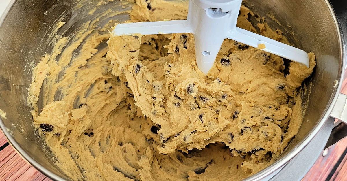 Chocolate chips added to gluten free cookie dough in a stand mixer with paddle attachment.