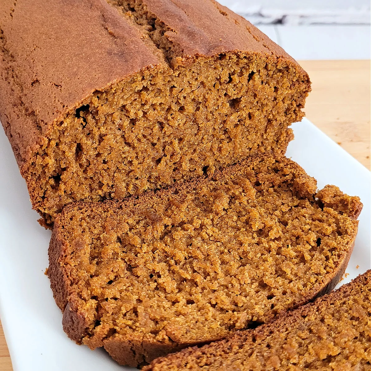 Gluten free pumpkin bread sliced and served on a white serving platter.