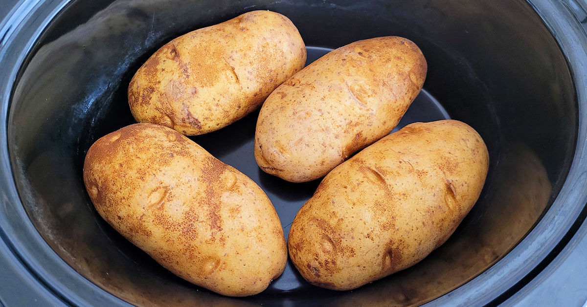 4 clean russet potatoes in a slow cooker.
