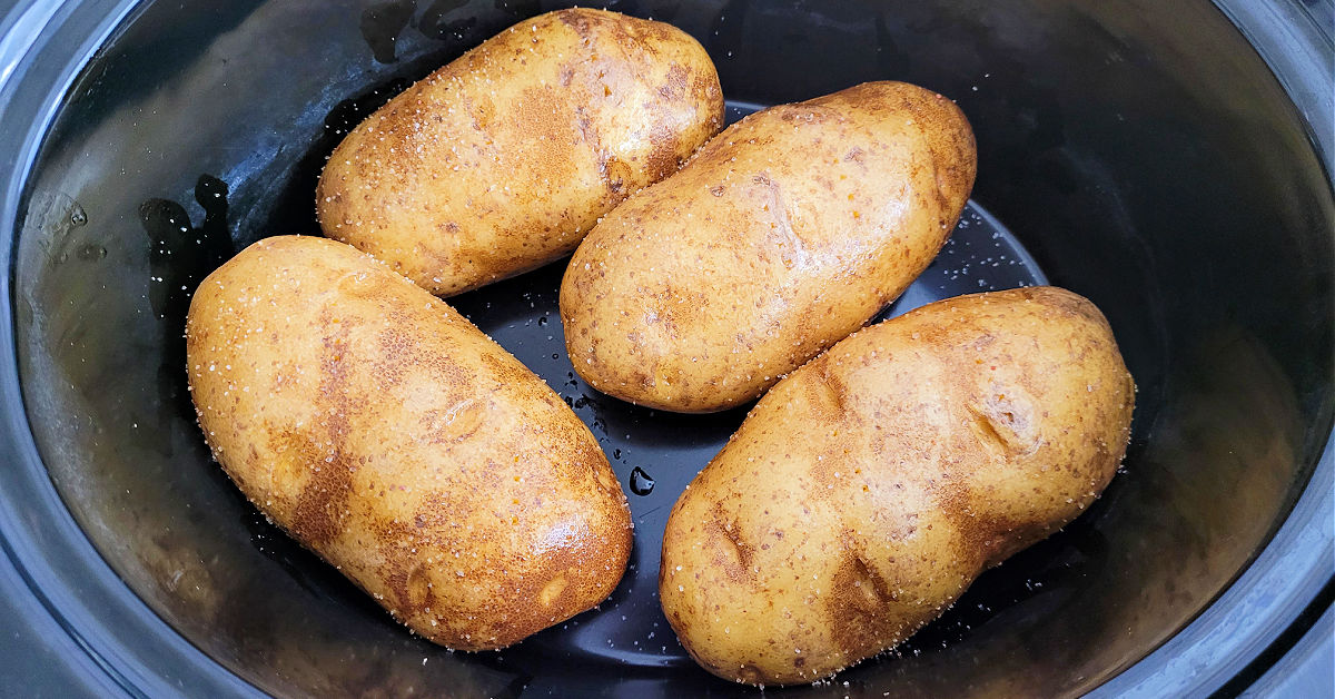 4 baked potatoes rubbed with olive oil in a slow cooker.