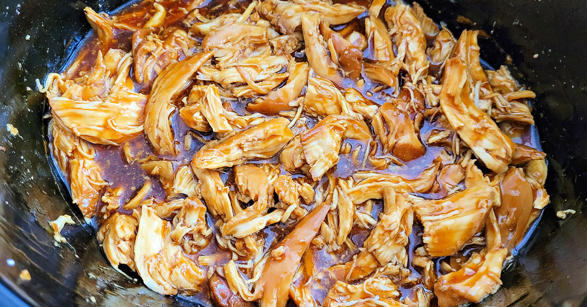 Shredded chicken added to thickened teriyaki sauce in the slow cooker.