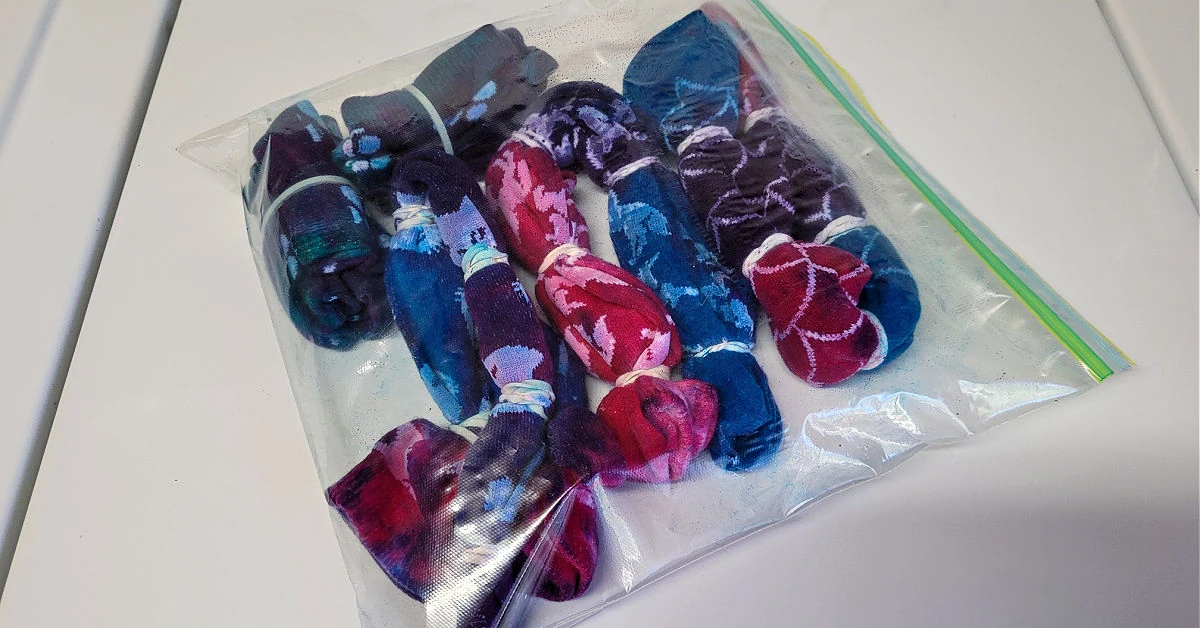 Wet tie dyed socks in a large plastic bag so the color can set.